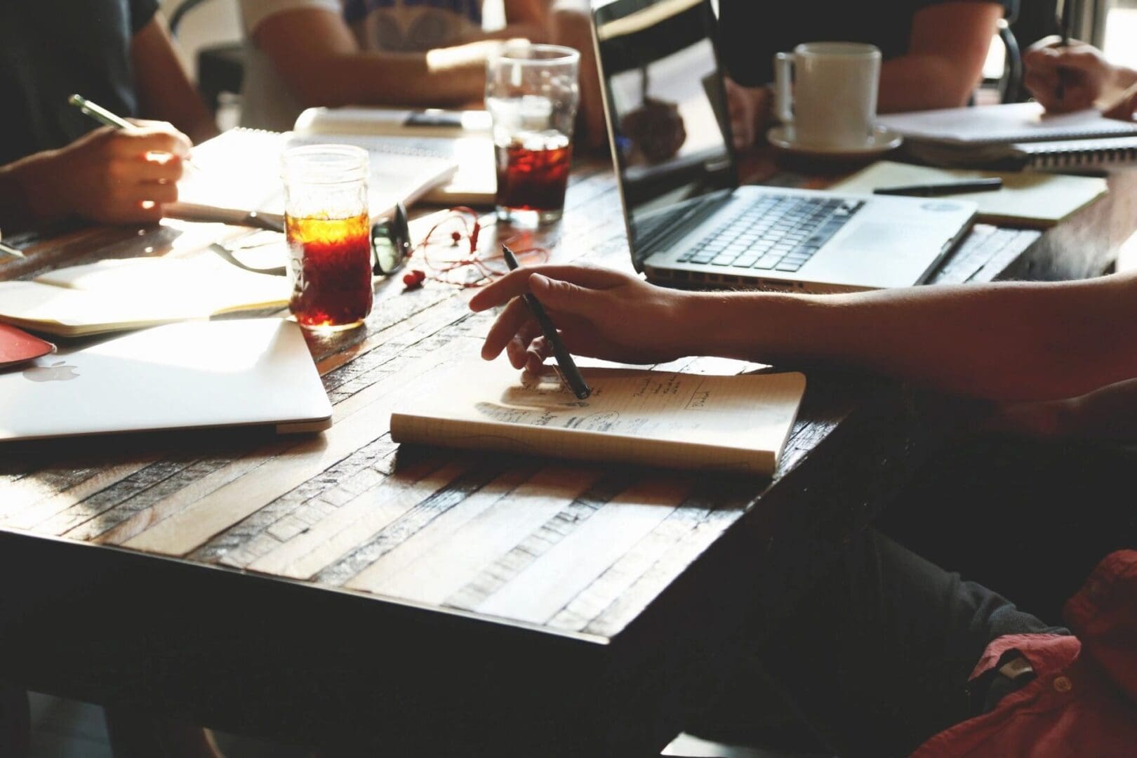 A person is typing on a laptop at a table.