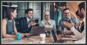 A diverse group of five professionals sitting around a table, laughing and engaging in a transparent, upbeat meeting.