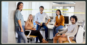A diverse group of five smiling colleagues posing together in a bright, modern office, conveying a sense of community and trust.