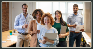 A diverse team of five professionals stands together in a well-lit office, smiling confidently at the camera.
