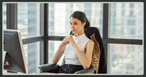 A professional woman in a white top sitting in a high-back office chair with a leopard-print jacket, looking thoughtfully toward an office window.